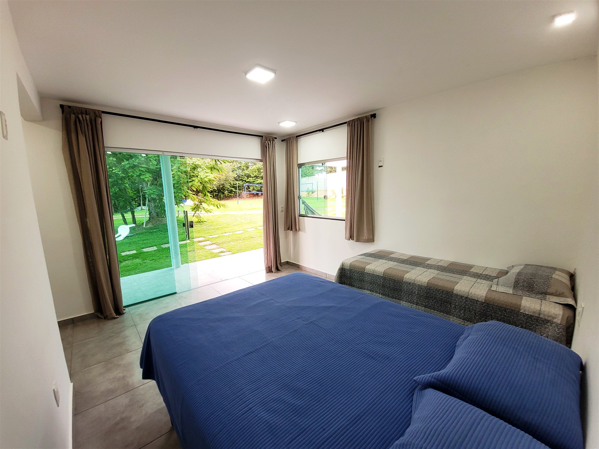 Suíte espaçosa com cama de casal e camas de solteiro